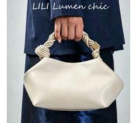 Cremefarbene glatte Handtasche mit dickem geflochtenem Seilgriff, gesichert mit quadratischen goldfarbenen Metallbeschlägen. Gebogene weiche Halbmond-